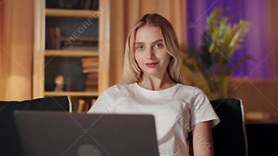 Captured in this stock footage is a moment of a young woman engaged with a laptop while at home