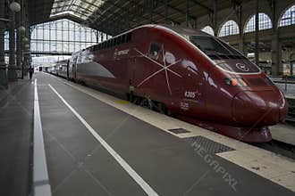 A red Eurostar train at the Gare du Nord train station platform