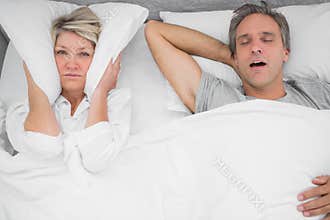 Man snoring loudly as partner blocks her ears