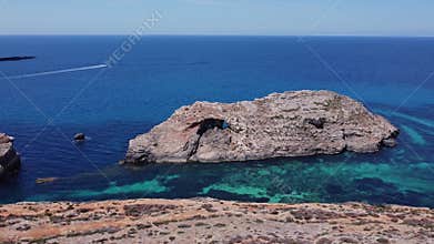 Natural windows in the rocks, Comino Island Malta, Orbiting drone shot