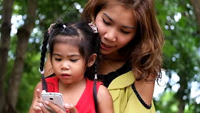 An asian girl and mother are using smart phone.