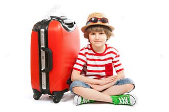 The summer boy sits at red trunk