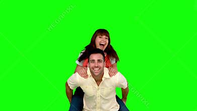 Smiling man giving to his friend a piggyback