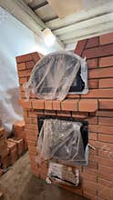 Building a new heating stove. The firebox and oven doors are installed. The oven is covered with concrete panels. Vertical video