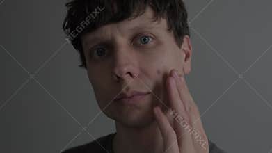 Acne and skin problem. Close up of man touching pimple on face, male skincare, dermatology concept, real life lifestyle.
