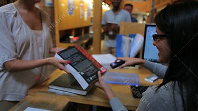 Librarian handing books to people to check out