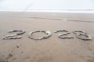 The stones arranged neatly on the beach form the number 2028