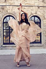 Beautiful woman with dark hair in luxurious silk dress