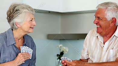 Senior couple playing cards at the counter