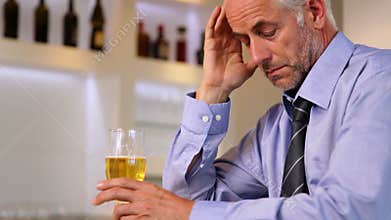Worried businessman drinking a beer after work
