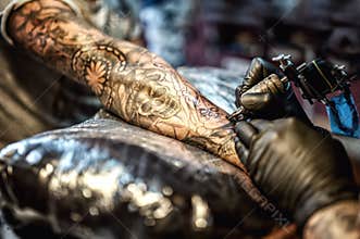 Tattoo artist drawing on arm and on skin of client