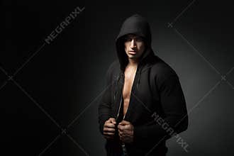 Strong man wearing hoodie isolated on black background