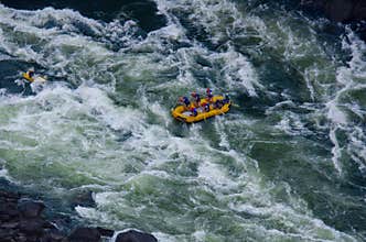 A group of people white water rafting on the Zambezi River.