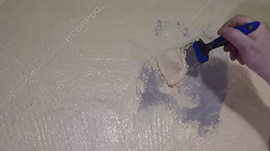Closeup Of Hand Smoothing Paint Edge. Indoor Scene Showing Detailed Wall Patch And Texture Blending