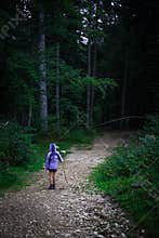 Child girl walking on a trail in a forest