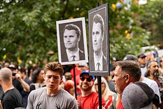 View of Charlie Kirk posters at anti-immigrant rally.