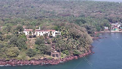 Aerial drone view of the historic Terekhol Fort, a heritage hotel on a coastal cliff at the northern tip of Goa, India