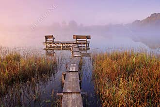 Wooden bridge with benches near home for relaxation.