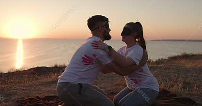 Gender party with blindfolded at sunset