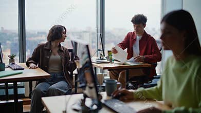 Young programmers coding computers sitting together at spacious coworking zone