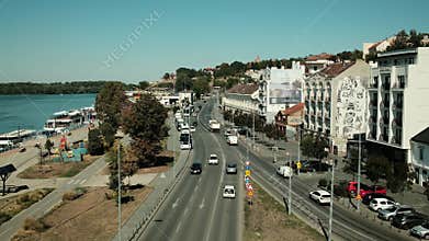 Cityscape of Belgrade with street view, cars, buses, and buildings near the riverside promenade on a sunny day. Horizontal 4k