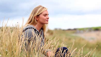 Blonde woman relaxing in the dunes