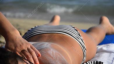 Woman applying sun block on young teen