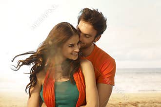 Attractive young woman getting a kiss at beach