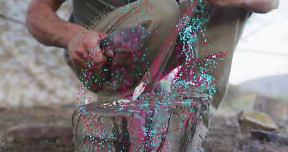 Man placing stick on stump, lifting hatchet and shaving wood curls for wood carving project