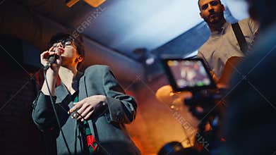 Musical band performing bar stage recorded by professional videographer closeup