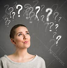 Young woman thinking with question marks over head