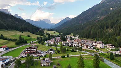 Aerial forward drone flight above Soraga, Val di fassa valley, Trentino, a town in the Italian dolomites. Church and houses