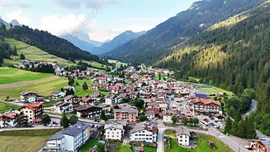 Aerial forward drone flight above Soraga, Val di fassa valley, Trentino, a town in the Italian dolomites. Church and houses