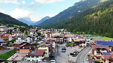 Aerial forward drone flight above Soraga, Val di fassa valley, Trentino, a town in the Italian dolomites. Church and houses