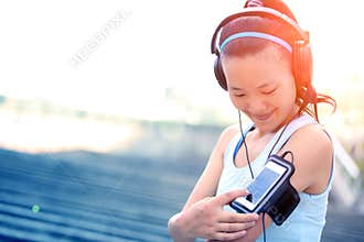 Runner athlete listening to music in headphones from smart phone mp3 player