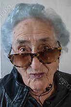 Grandmother with sunglasses, headphones and leather jacket
