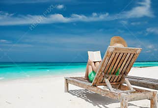 Young woman reading a book at beach