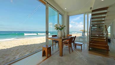 Beachfront dining room showcases ocean views with a wooden table and modern staircase design
