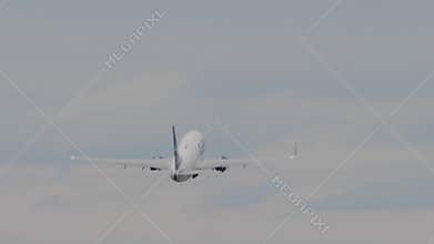 Commercial aircraft taking off, retracting landing gear and climbing