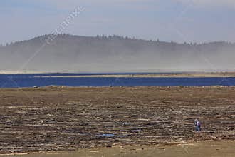 Two people in the distance exploring the ground that is normally underwater in Baskatong, Quebec, Canada