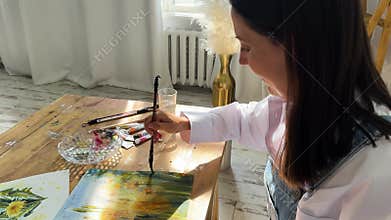 A joyful artist proudly showcasing their colorful paint brushes in a bright and inspiring studio environment