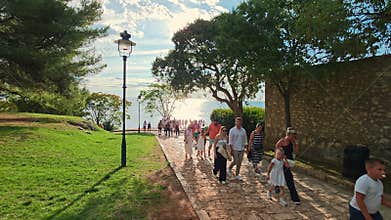 Rovinj Croatia 03.08.2025 Tourists and families walking along a scenic stone pathway under the trees overlooking the