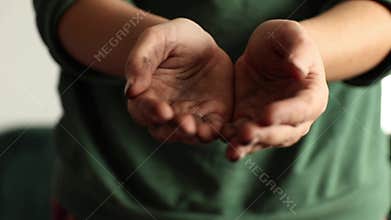 Close-up of dirty hands soiled with earth cupped in begging gesture. Powerful concept of poverty, hardship and charity
