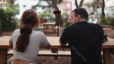 Influencers couple live streaming in a park with a smartphone