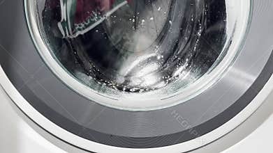 The washing machine runs an active cycle with the drum