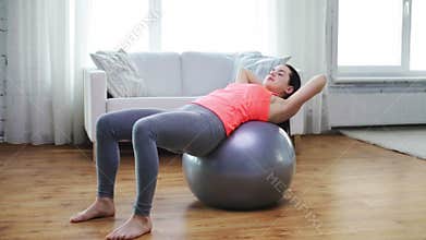 Girl exercising with fitness ball at home