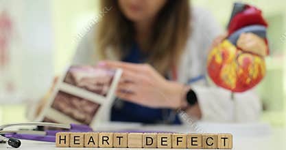 Woman cardiologist examines printed ultrasound images of heart