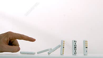 Finger pushing over dominoes