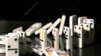 Finger pushing over colourful dominoes