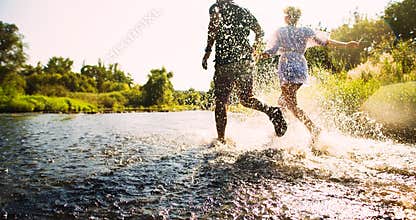 Happy couple running in shallow water
